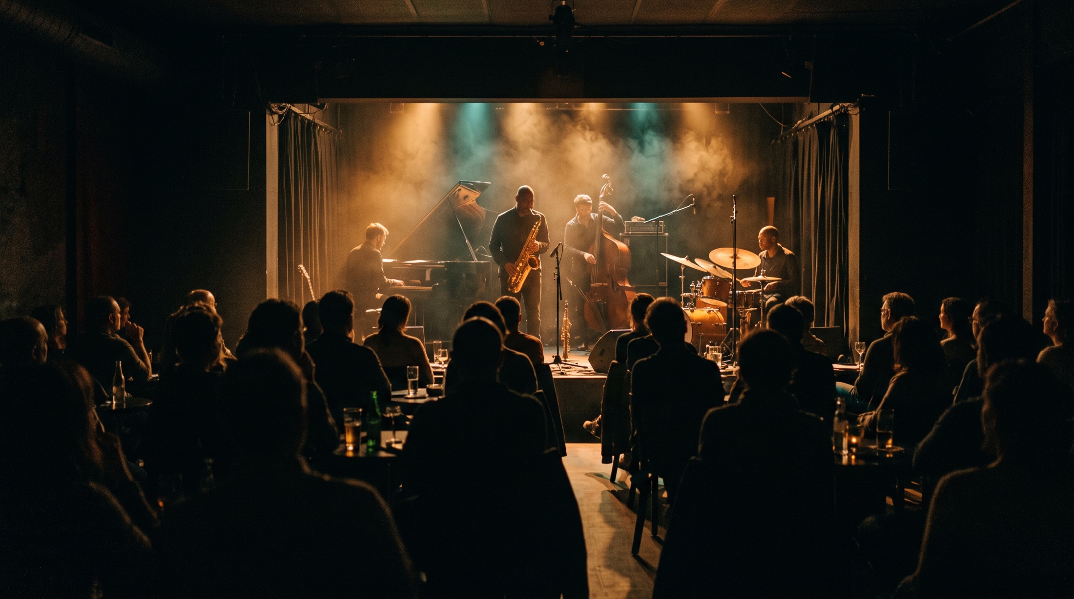 A lit stage viewed from the back of an intimate club
